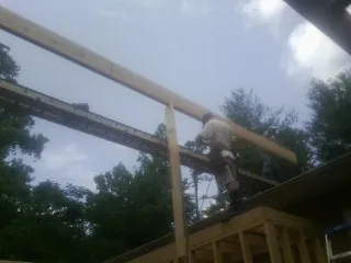 Carpenter setting a ridge beam over a new addition frame — Ice Dam Removal by Roofing Brothers in Longmeadow