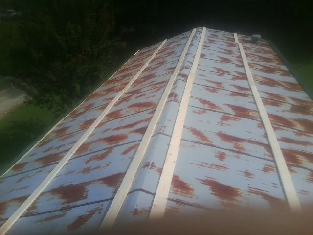 Rusted metal roof panels with new wood purlins before replacement — Storm Damage Roof Repair in Longmeadow by Roofing Brothers