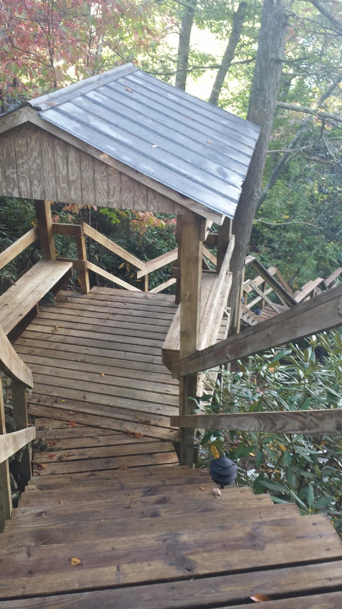 Metal roofed shelter over wooden steps on a wooded walkway — Skylight Repair & Installation work by our crew in Longmeadow